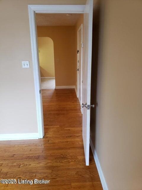 hallway with hardwood / wood-style floors