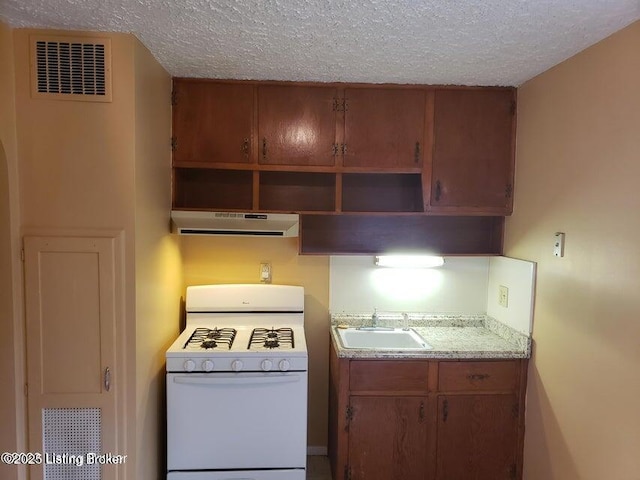 kitchen with white range with gas cooktop, sink, and a textured ceiling