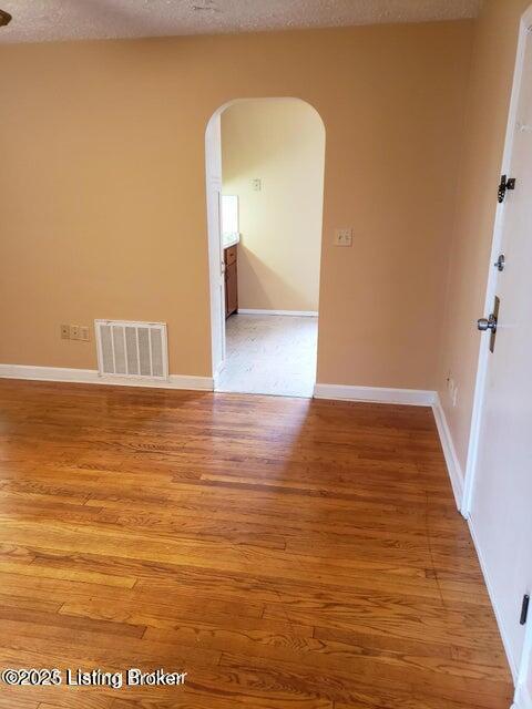 unfurnished room featuring a textured ceiling and hardwood / wood-style flooring