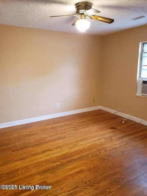 empty room featuring hardwood / wood-style floors, a textured ceiling, ceiling fan, and cooling unit