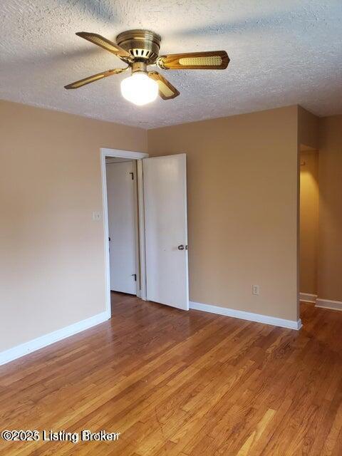 empty room with wood-type flooring, a textured ceiling, and ceiling fan