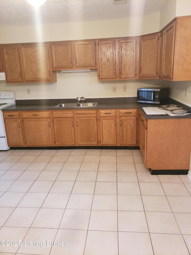 kitchen featuring light tile patterned floors, white range oven, range hood, and sink