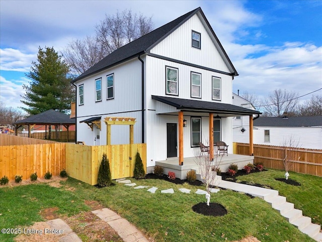 modern farmhouse with a front yard and covered porch