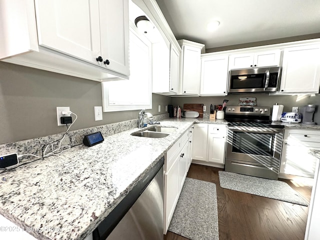 kitchen with white cabinets, light stone counters, sink, and stainless steel appliances