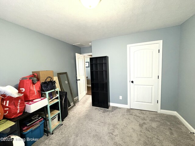 misc room featuring light colored carpet and a textured ceiling