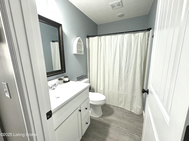 bathroom featuring wood-type flooring, vanity, and toilet