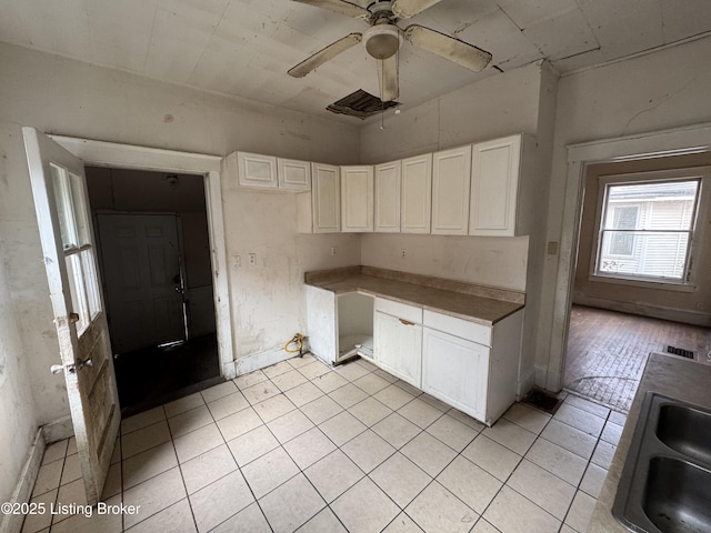 kitchen featuring white cabinets, light tile patterned floors, ceiling fan, and sink