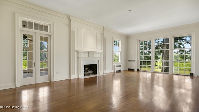 unfurnished living room with french doors, crown molding, a premium fireplace, radiator heating unit, and dark hardwood / wood-style floors