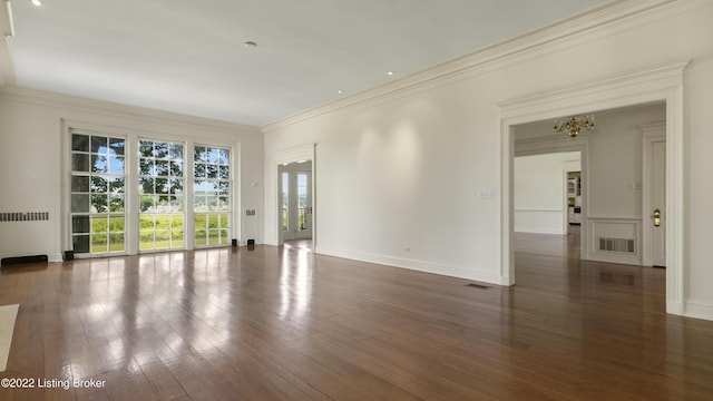 unfurnished room featuring radiator, crown molding, dark hardwood / wood-style floors, and a notable chandelier