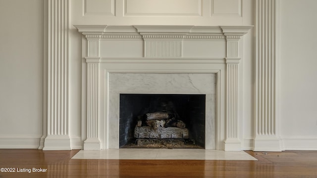 interior details featuring hardwood / wood-style floors and a high end fireplace