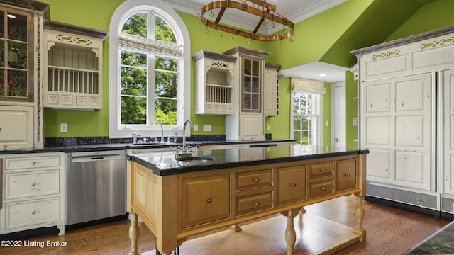 kitchen with dishwasher, crown molding, dark stone countertops, a kitchen island, and dark hardwood / wood-style flooring