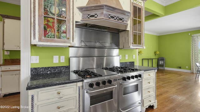 kitchen with white cabinetry, crown molding, wood-type flooring, range with two ovens, and custom range hood