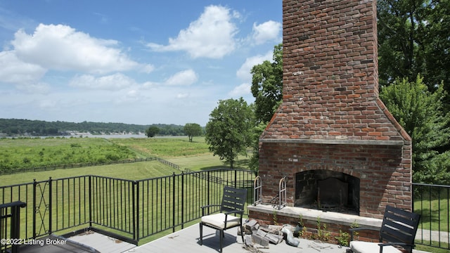 wooden deck featuring a yard, a rural view, and an outdoor brick fireplace