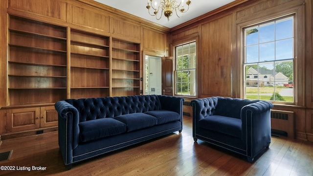 living room with radiator, wood walls, plenty of natural light, and built in features