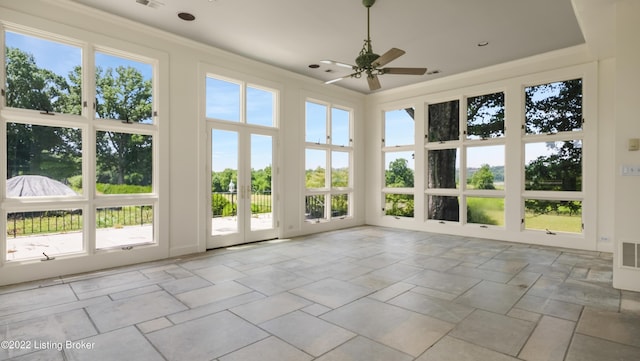 unfurnished sunroom featuring ceiling fan and french doors