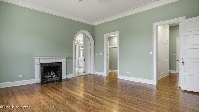 unfurnished living room featuring crown molding, ceiling fan, a fireplace, and wood-type flooring