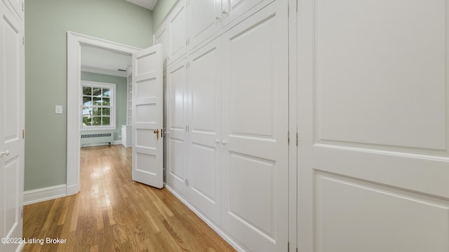 hallway featuring light wood-type flooring and radiator heating unit