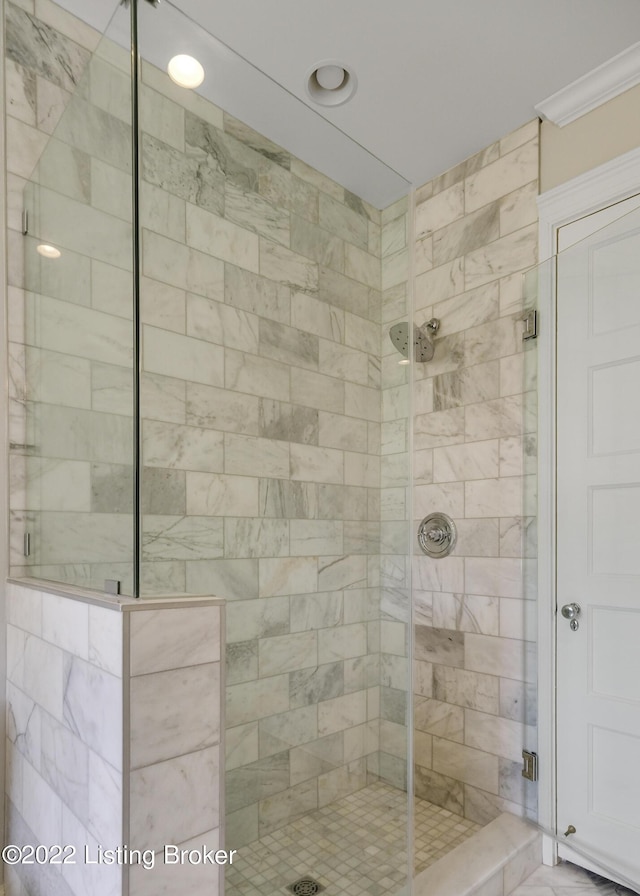 bathroom featuring an enclosed shower and crown molding