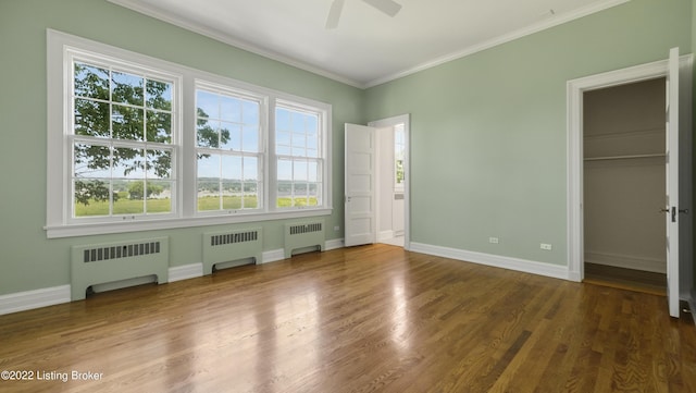 unfurnished bedroom with hardwood / wood-style floors, ceiling fan, and radiator