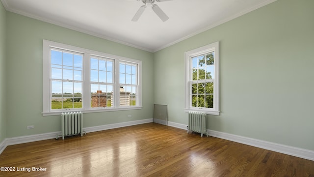 spare room with hardwood / wood-style flooring, ceiling fan, ornamental molding, and radiator