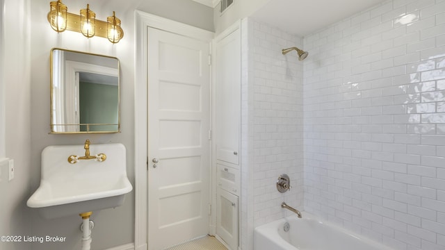 bathroom featuring tiled shower / bath and sink