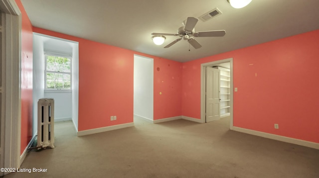 unfurnished room with radiator heating unit and ceiling fan