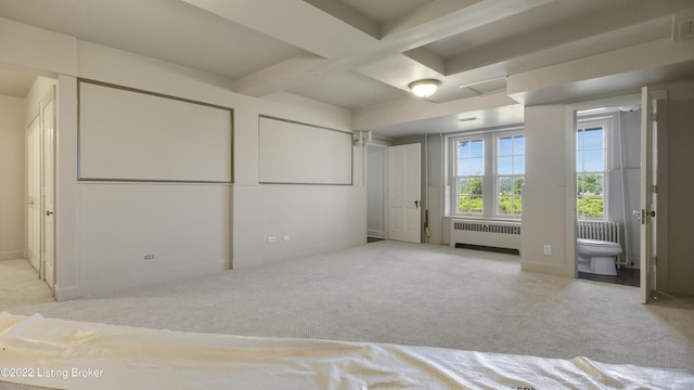 unfurnished bedroom featuring connected bathroom, light colored carpet, and radiator