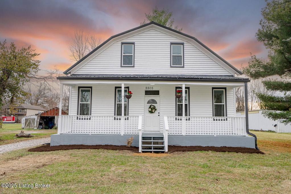 view of front of property featuring a porch and a yard