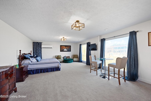 carpeted bedroom featuring a wall mounted air conditioner and a textured ceiling