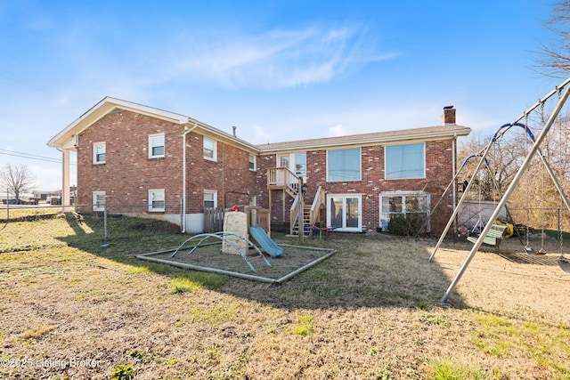 back of property with a playground and a lawn