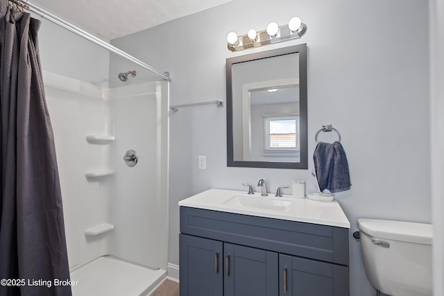 bathroom featuring vanity, toilet, a textured ceiling, and walk in shower