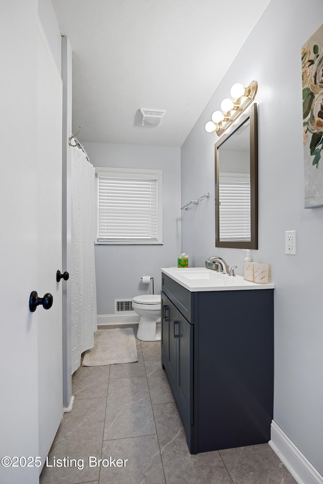 bathroom with tile patterned flooring, vanity, and toilet