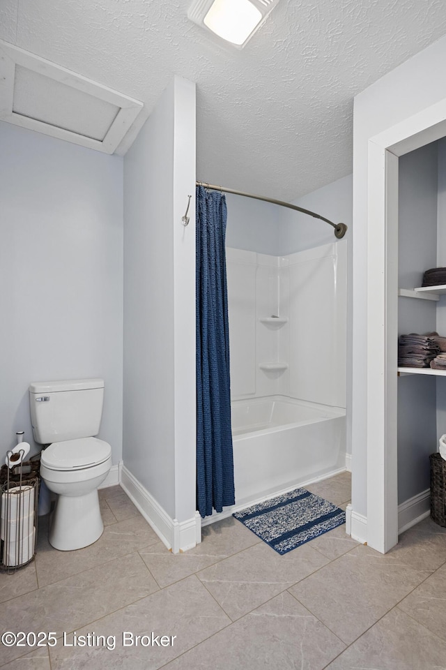 bathroom featuring tile patterned flooring, toilet, and a textured ceiling