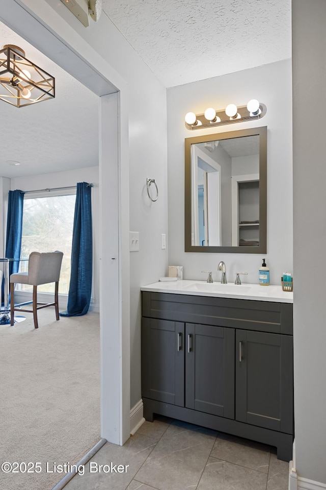 bathroom featuring tile patterned flooring, vanity, and a textured ceiling