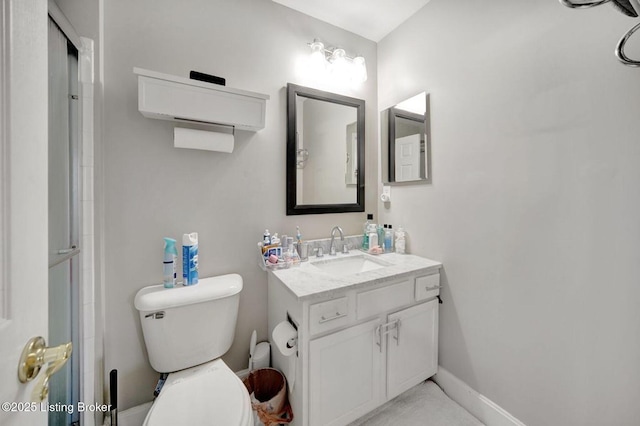 bathroom featuring vanity, toilet, and walk in shower