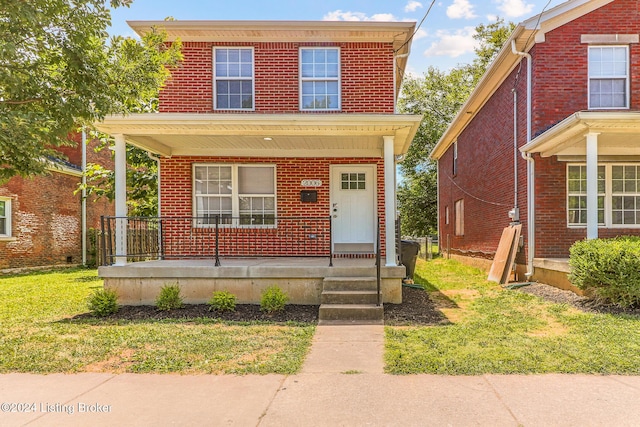 front of property featuring covered porch and a front lawn