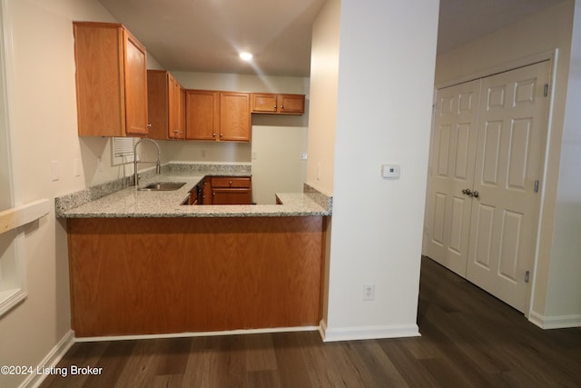 kitchen with light stone counters, sink, and dark hardwood / wood-style floors