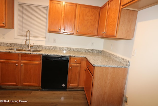 kitchen with dark hardwood / wood-style flooring, light stone countertops, sink, and black dishwasher