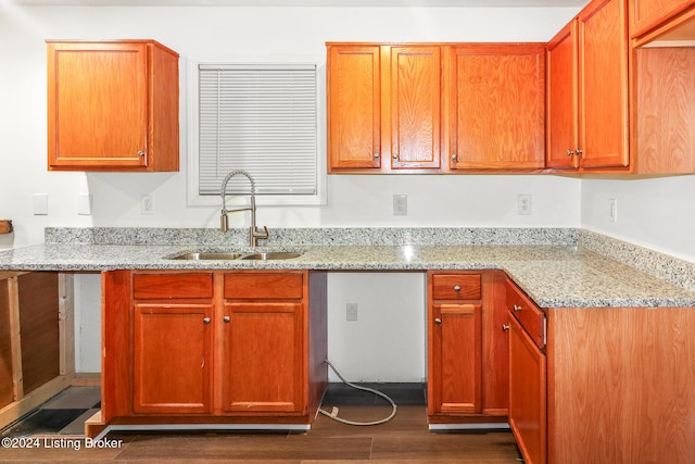 kitchen with light stone countertops, dark hardwood / wood-style flooring, and sink