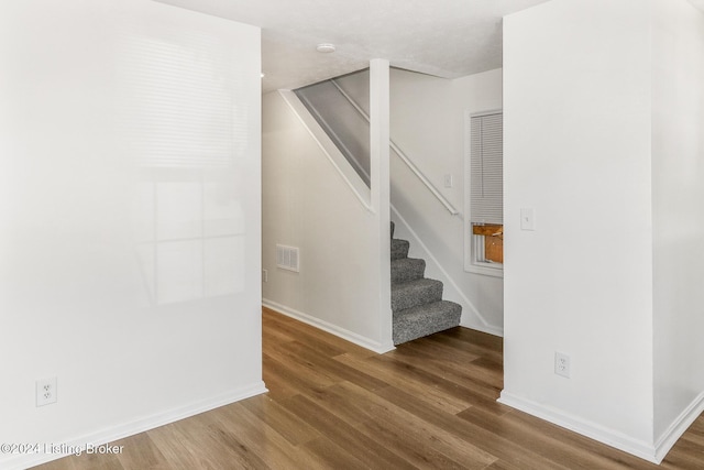 staircase with hardwood / wood-style floors