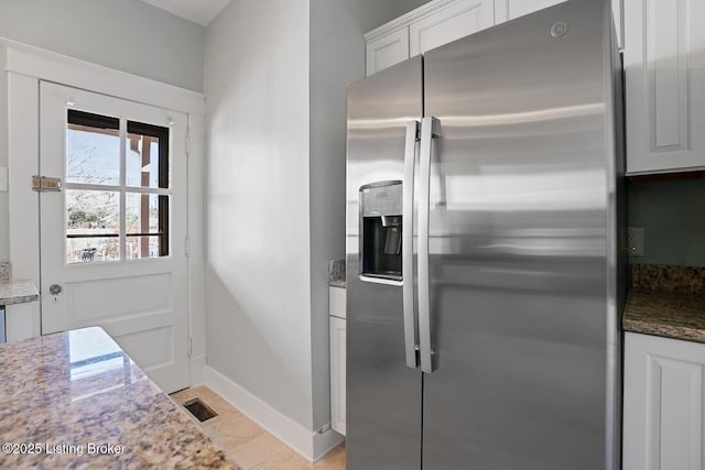 kitchen featuring white cabinetry, light stone counters, and stainless steel fridge with ice dispenser