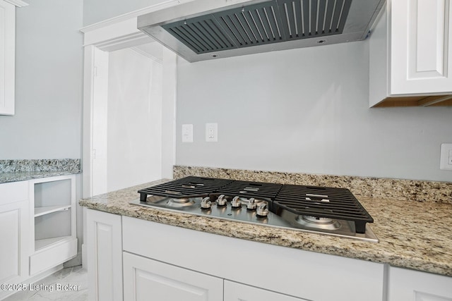 kitchen with light stone counters, extractor fan, stainless steel gas stovetop, and white cabinets