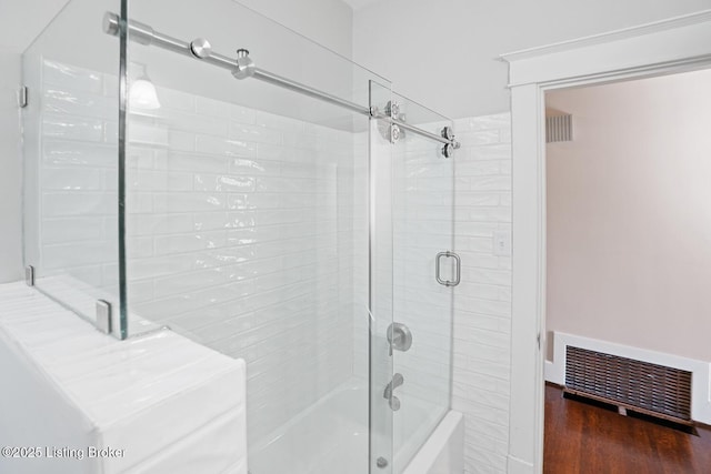 bathroom with enclosed tub / shower combo and hardwood / wood-style floors