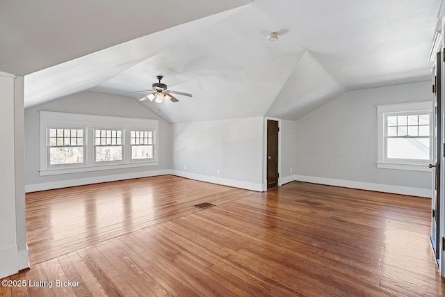 additional living space with lofted ceiling and hardwood / wood-style floors