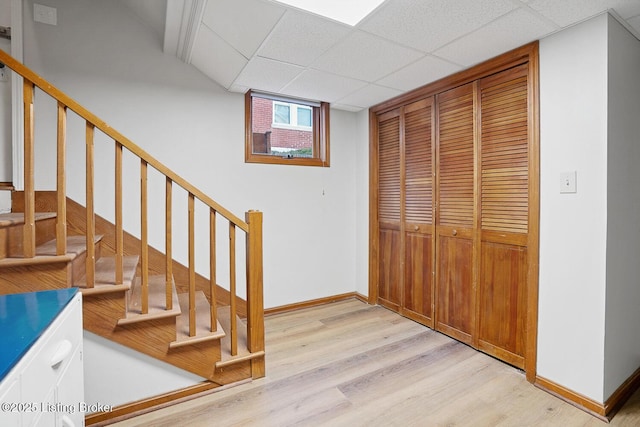 stairway with a paneled ceiling and hardwood / wood-style floors