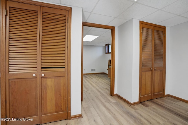 corridor featuring a paneled ceiling and light hardwood / wood-style floors