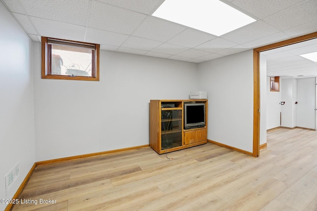 interior space with a paneled ceiling and light hardwood / wood-style floors