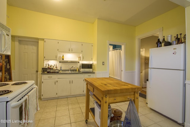 kitchen with sink, white appliances, white cabinetry, and light tile patterned flooring