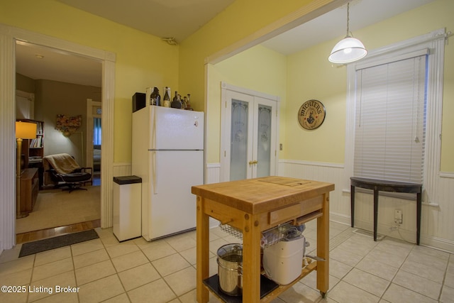 kitchen with pendant lighting, white fridge, and light tile patterned flooring