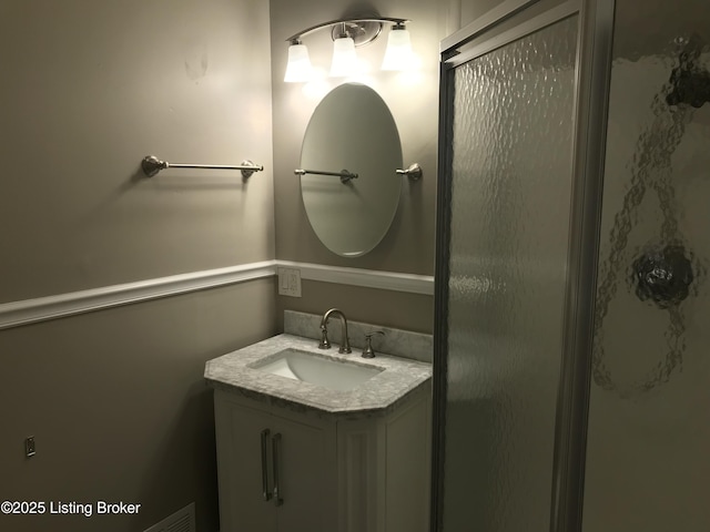 bathroom with walk in shower and vanity